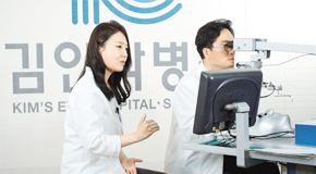 본보 이진한 의학전문기자(오른쪽)가 김안과병원 정종진 안과 교수의 도움을 받아 백내장 가상현실(VR) 시뮬레이터 기기로 백내장 수술을 간접체험하고 있다. 김안과병원 제공