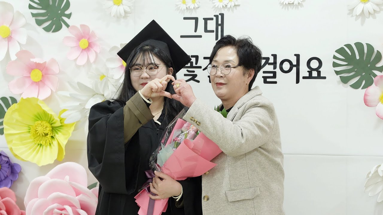 졸업생과 부모님(어머니)과 기념사진을 찍고 있다.